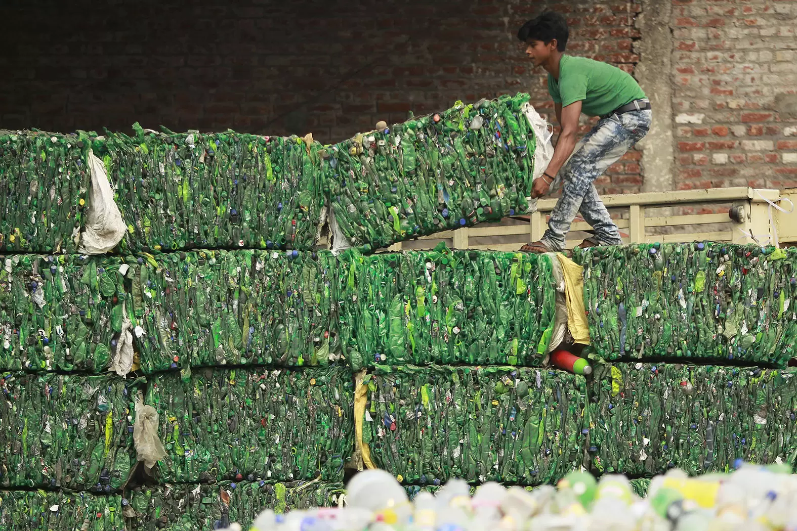 La pandémie de matière plastique | Un ouvrier range des ballots de plastique dans une usine de recyclage en Inde. Crédit : AP Photo/Channi Anand/SIPA | Françoise Blind-Kempinski - Directrice éditoriale et réalisatrice (journaliste Les Echos)